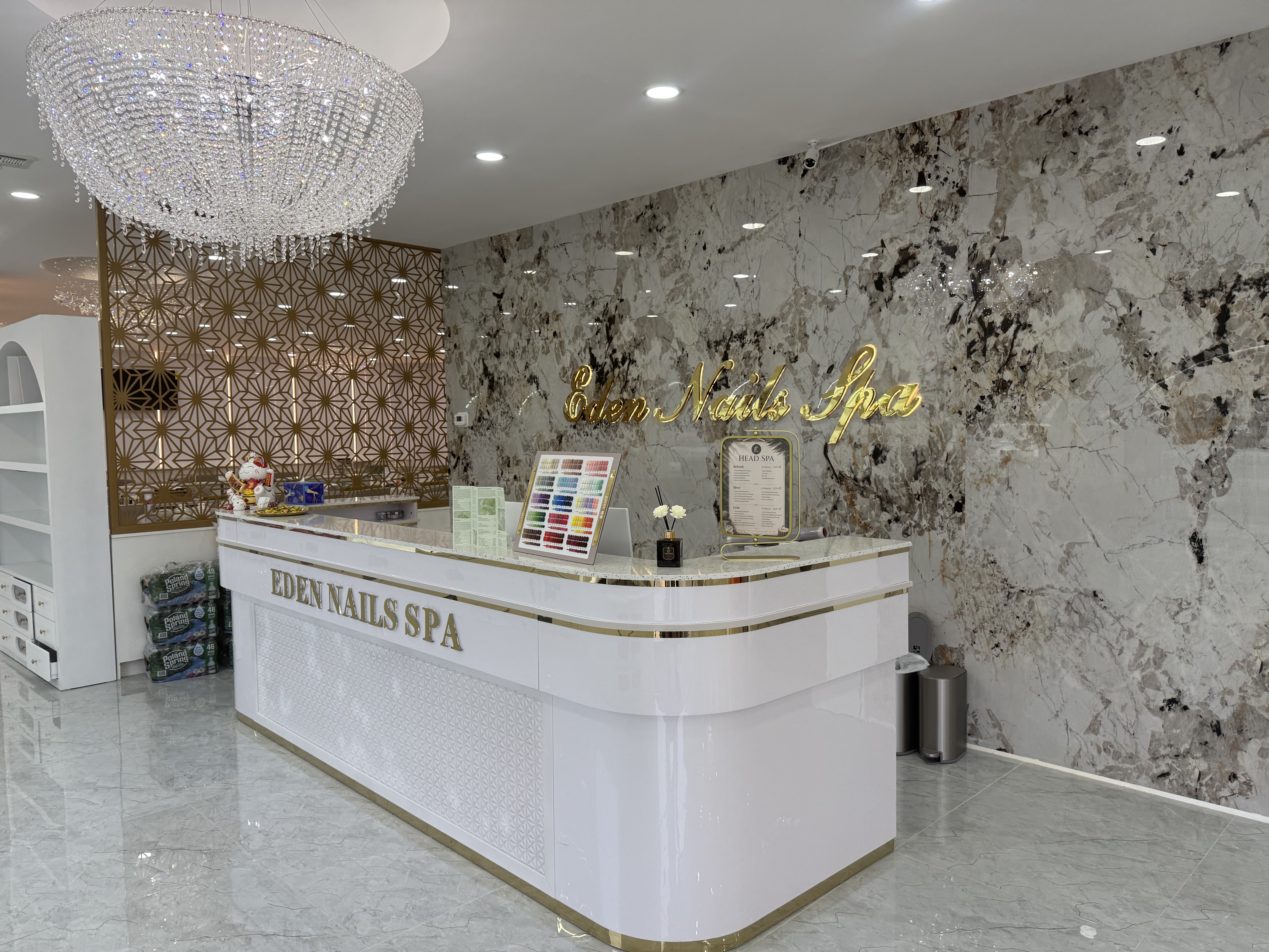 Eden Nail Spa reception desk with chandelier and marble wall